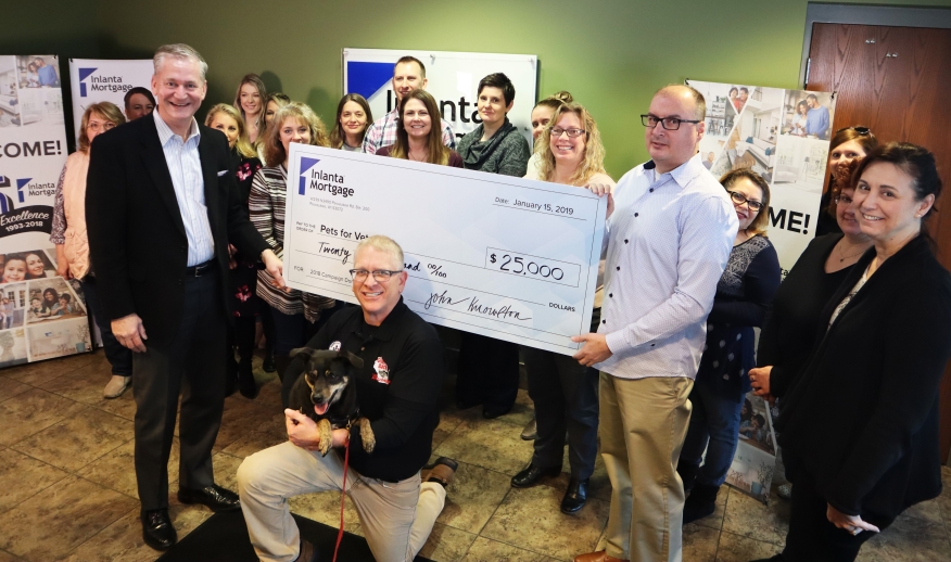 Paul Buege, Inlanta president and COO, center Dan Zeally, executive director for the Milwaukee area chapter of Pets for Vets with his rescue dog Bella, and Chris Knowlton, Inlanta CIO, along with members of Inlanta’s Pewaukee employee team