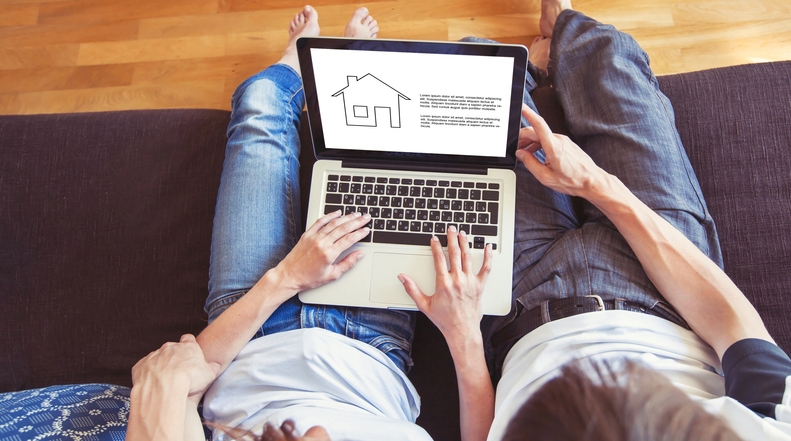 young family couple choosing new home online, search real estate to buy or rent, house for sale on screen of computer (Photo credit: Getty Images/anyaberkut)
