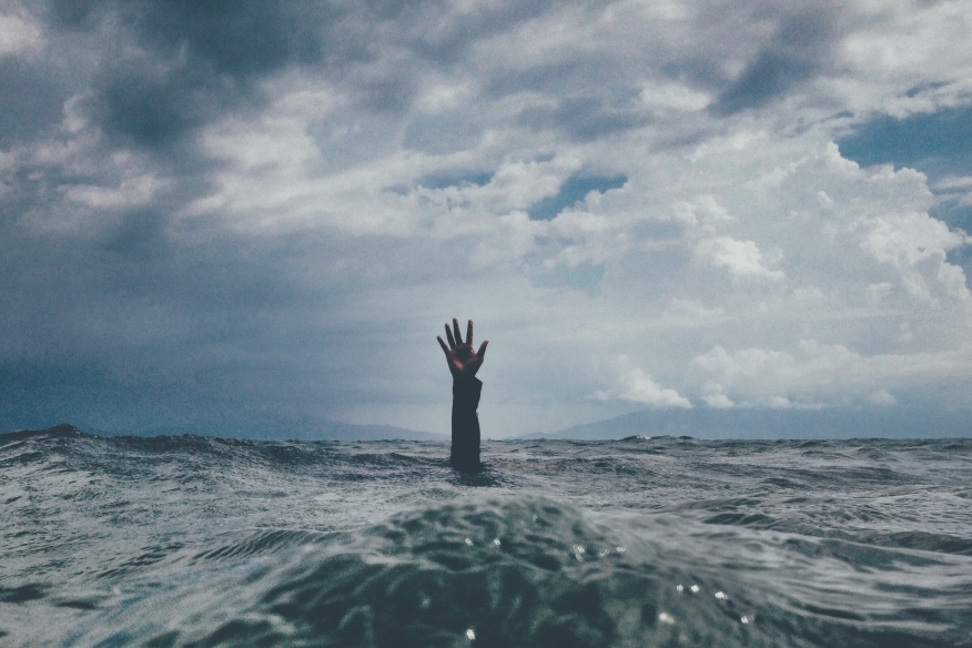 Hand coming up out of water.