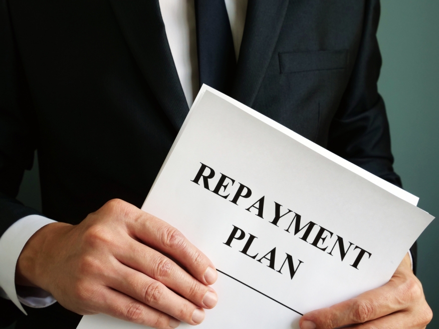 Person holding a repayment plan. Credit: iStock.com/designer491