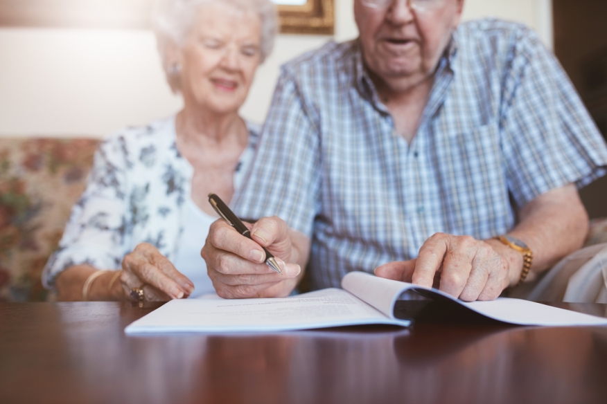 Older couple signing document. Credit: iStock.com/jacoblund