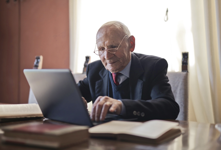 Elderly man using laptop.