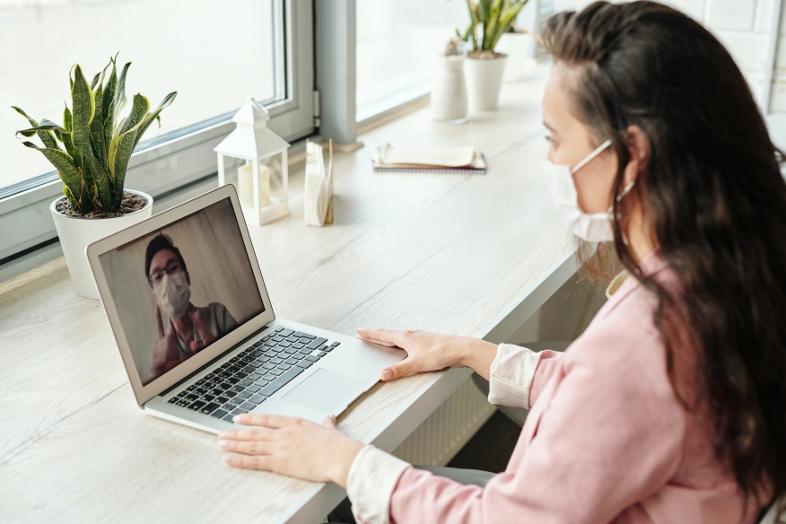 Woman working from home with face mask on.