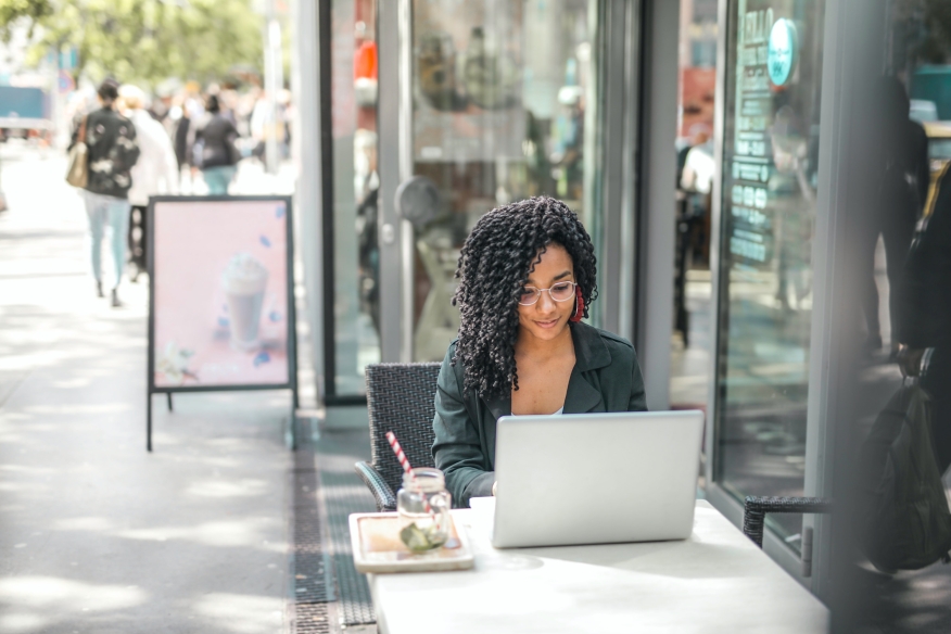 Woman browsing on her laptop from a coffee shop.