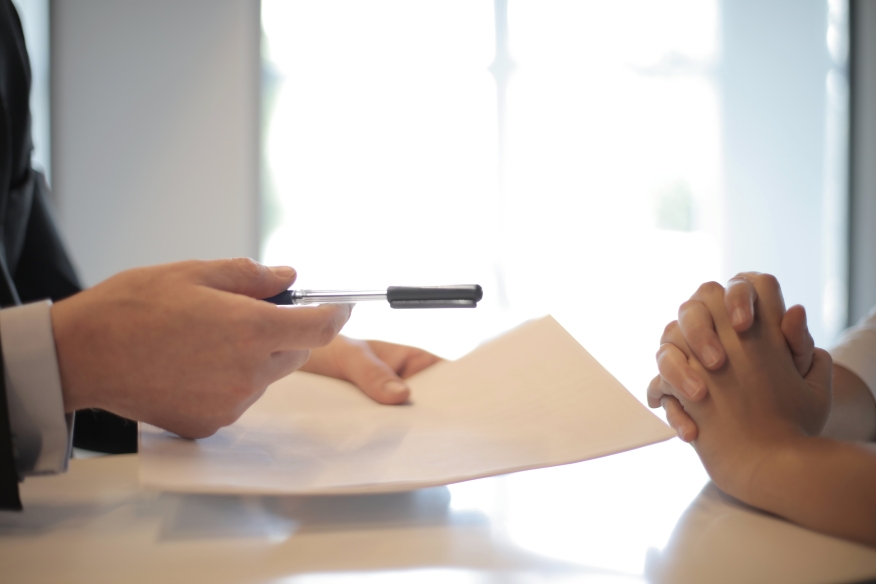 Agent handing over paperwork to be signed. 