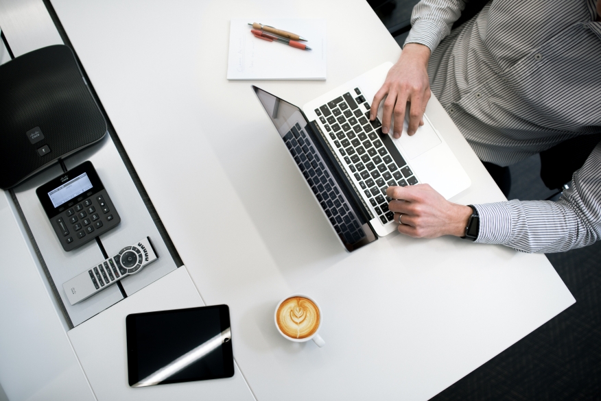 Person using a laptop at their desk. 