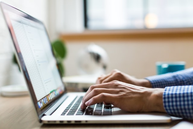 Man typing on his laptop.