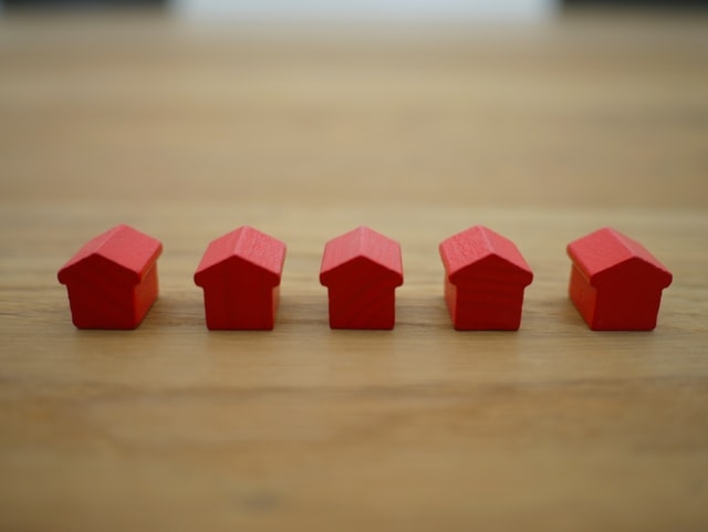 Tiny red house blocks on a desk. 