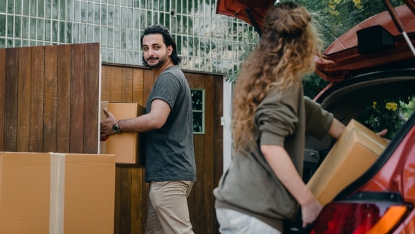 Photo of a couple moving in to their first home. 