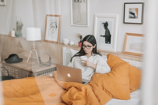 Millennial woman at home working off of her laptop.