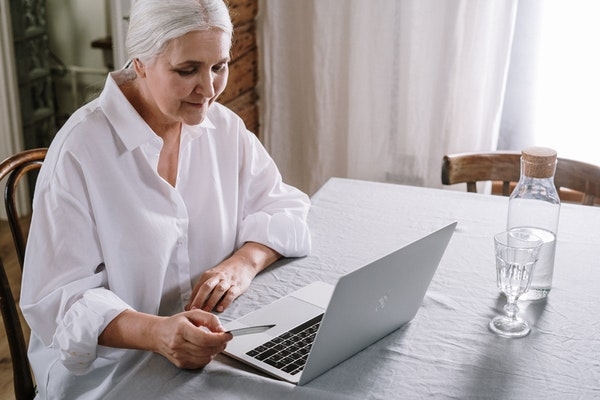 Elderly woman at home using her laptop.