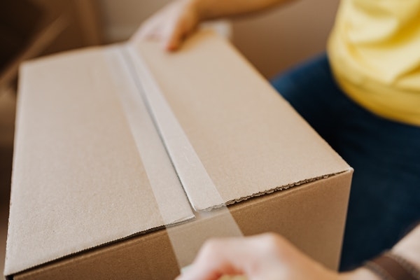 Photo of a person holding a moving box.