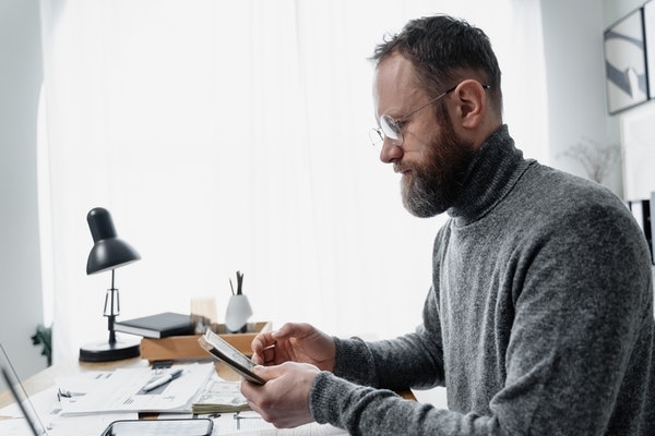 A man at his desk sorting out his bills.