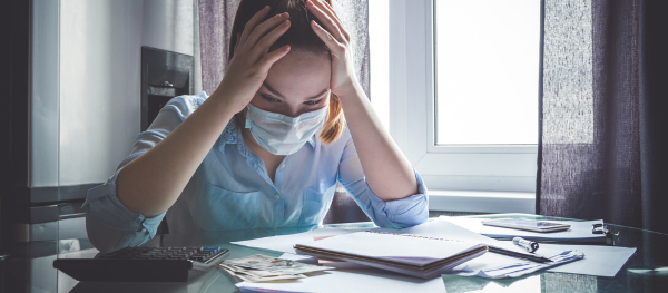 Photo of a woman looking worried while paying her bills.