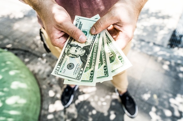 Photo of a person holding money in their hands.