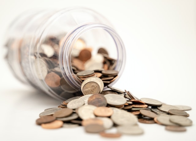 Photo of a spilled jar of coins.