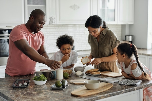 Photo of a family in their kitchen at home.