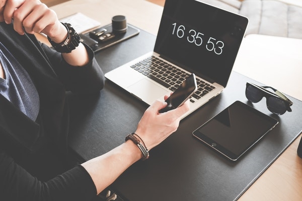 Photo of a person at their desk with multiple tech devices.