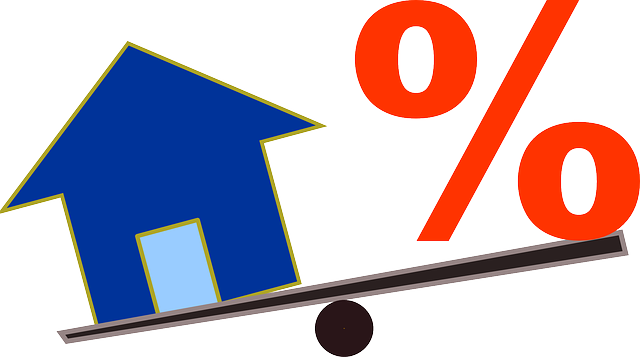 Photo of a house and percent sign on a seesaw.