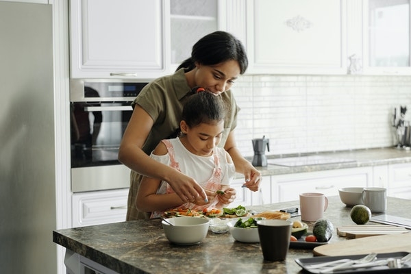 Photo of a mom and a daughter at home in the kitchen.