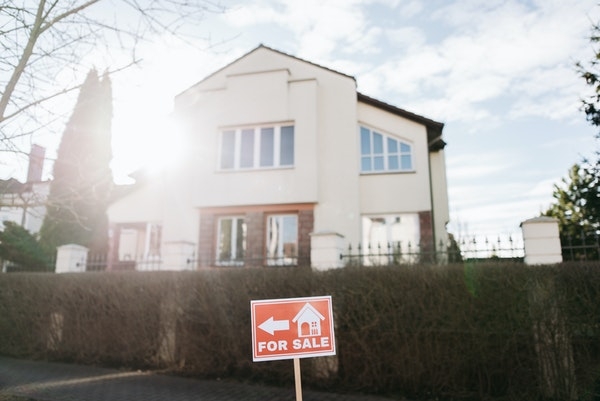 Photo of a for sale sign outside of a home.