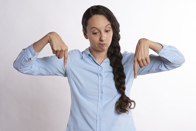 Photo of a woman pointing downward.