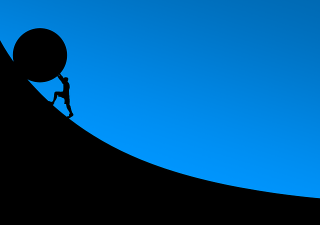 Image of someone pushing a boulder up a hill.