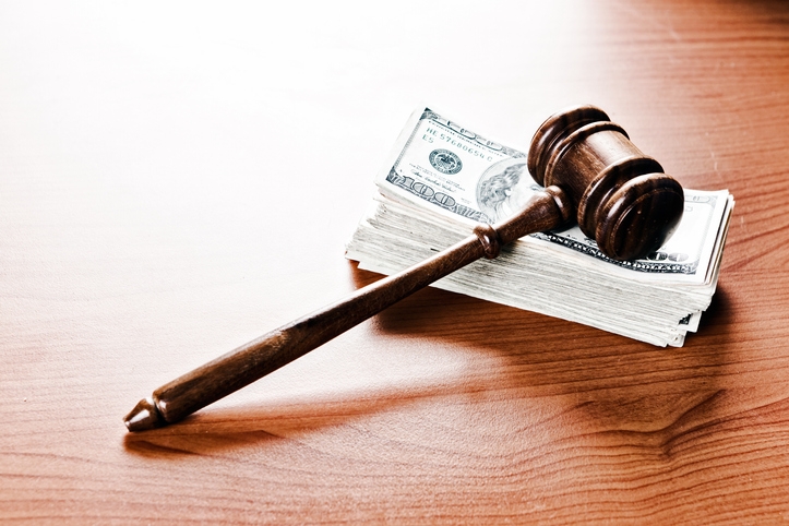 Photo of a gavel on a pile of money.