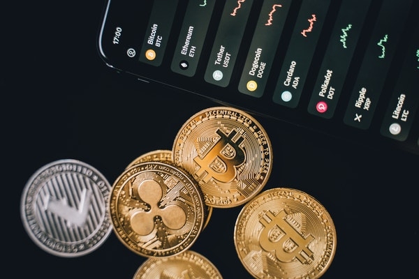 Photo of cryptocurrency coins and a cell phone. 