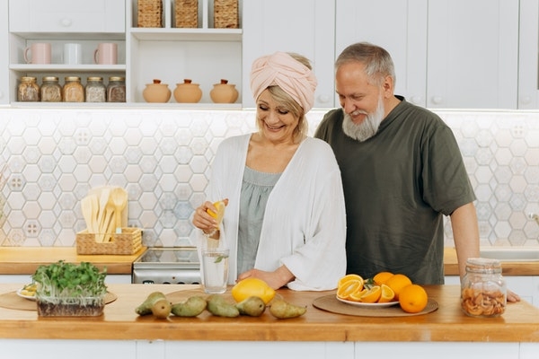 Photo of an older couple at home in their kitchen.