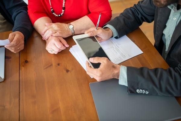 Photo of a couple going over paperwork with an agent.