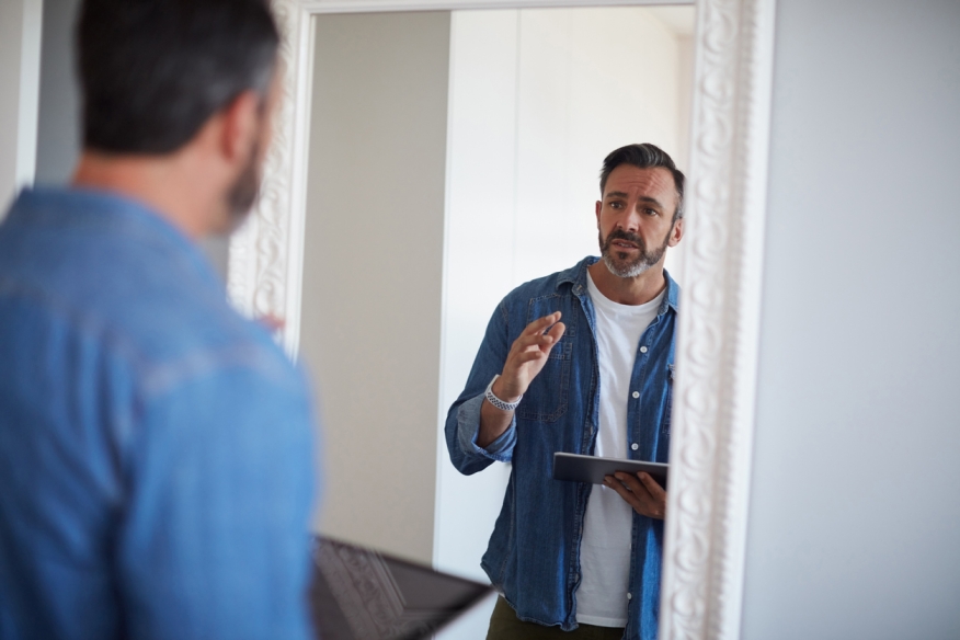 A mortgage professional talks to himself in the mirror.