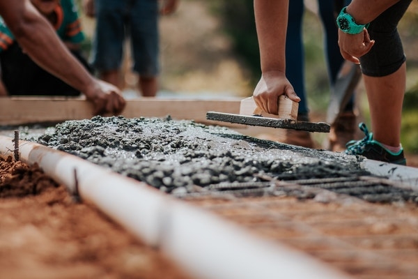 Photo of construction workers laying cement. 