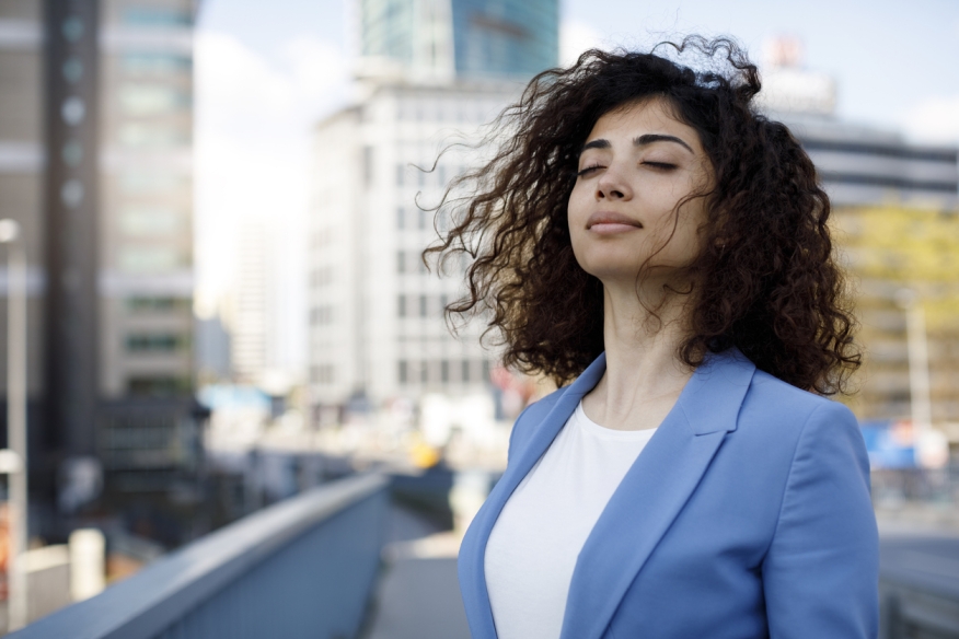 A business woman breathes in fresh air on a rooftop