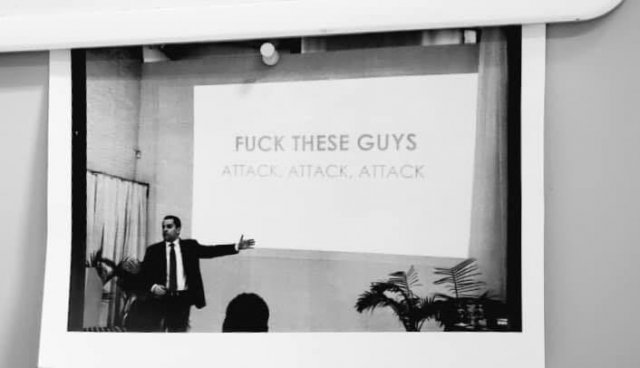 Anthoy Casa stands in front a presentation slide that reads "FUCK THESE GUYS. ATTACK. ATTACK. ATTACK."