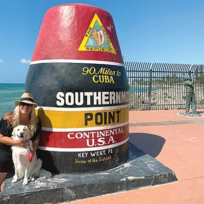 Kristen Eklund with her dog near the southernmost buoy on the Florida Keys