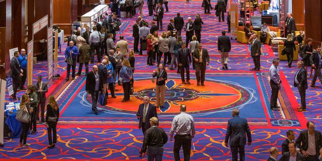 A large group of people standing on the exhibit floor at the New England Mortgage Expo