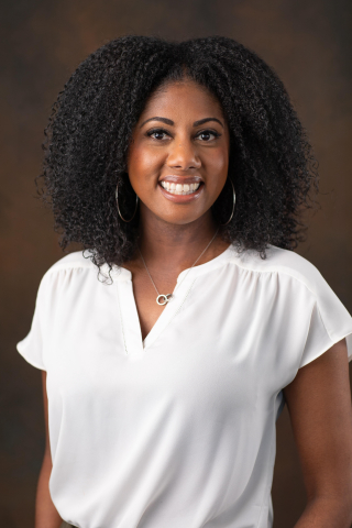 A woman with curly black hair and a white shirt