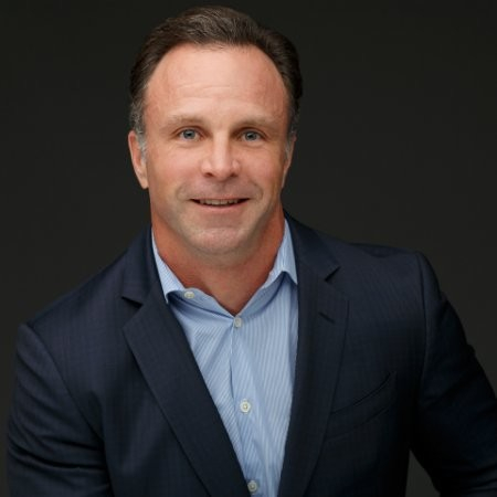 White man in a blue shirt and coat