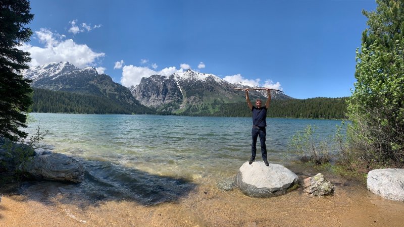 Glenn Stearns, CEO of Kind Lending, standing joyously above a lake.