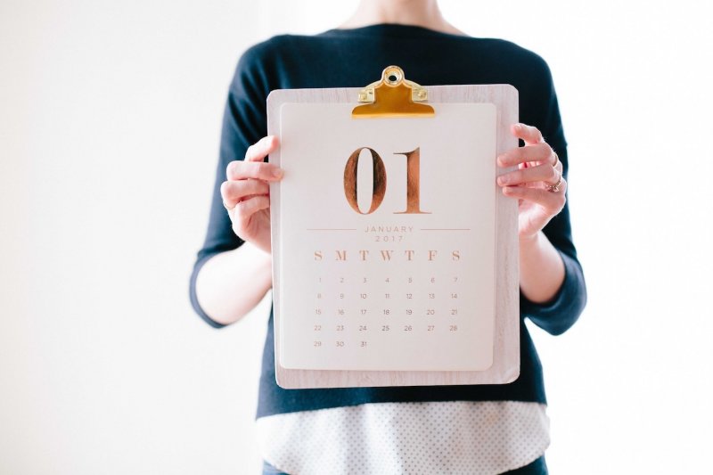 A woman holds up a calendar on January 1st.