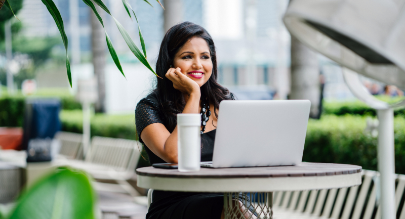 A woman smiles while working at an outdoor public space