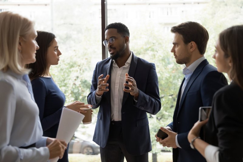 A confident businessman commands a conversation among colleagues. 