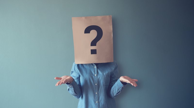 A woman shrugging her shoulders with a question mark over her face.
