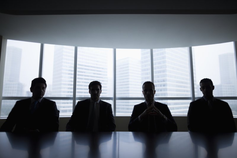 A row of NMLS regulators wait in dark silhouette.