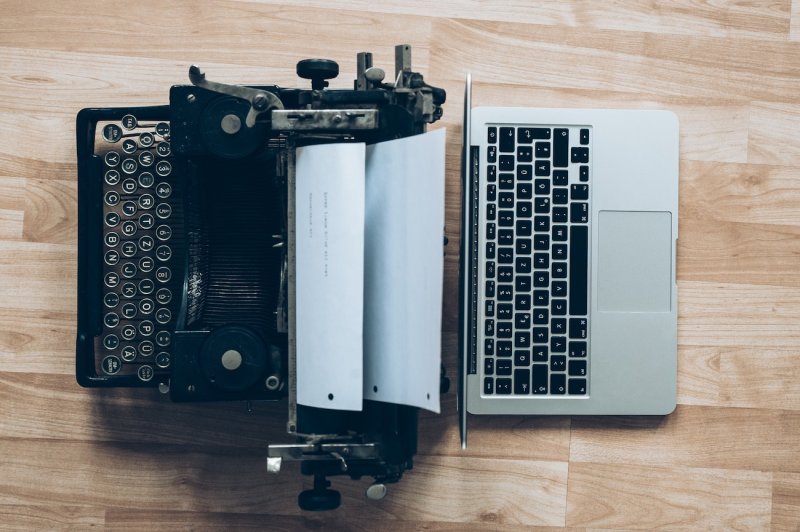 Aerial view of a typewriter and laptop back to back