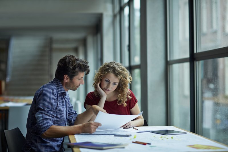 A senior colleague mentors another in the office