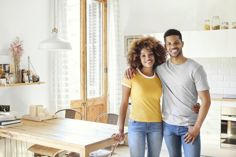A black couple standing together in their home.