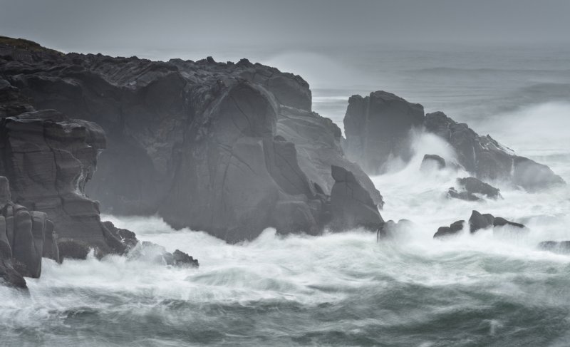 Stormy ocean water crashes on rocks
