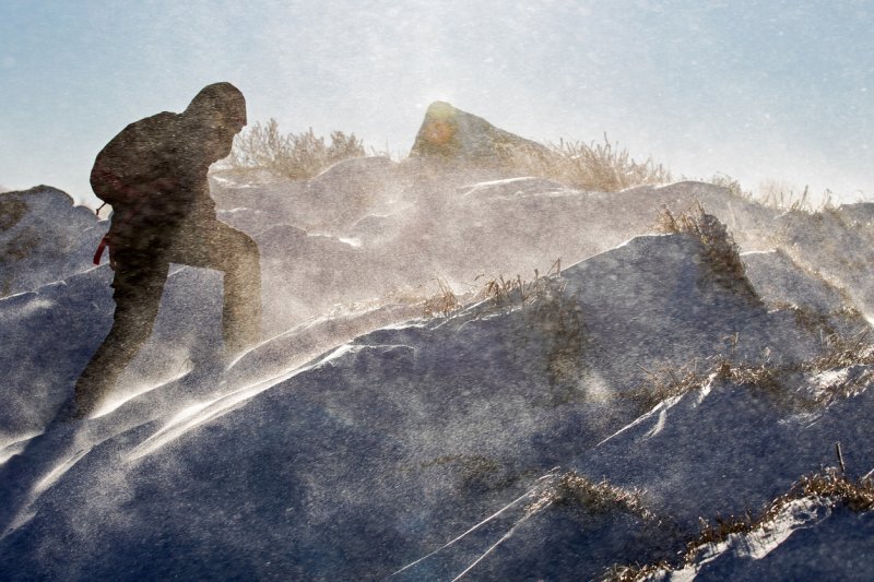 Woman climbing against a snow storm